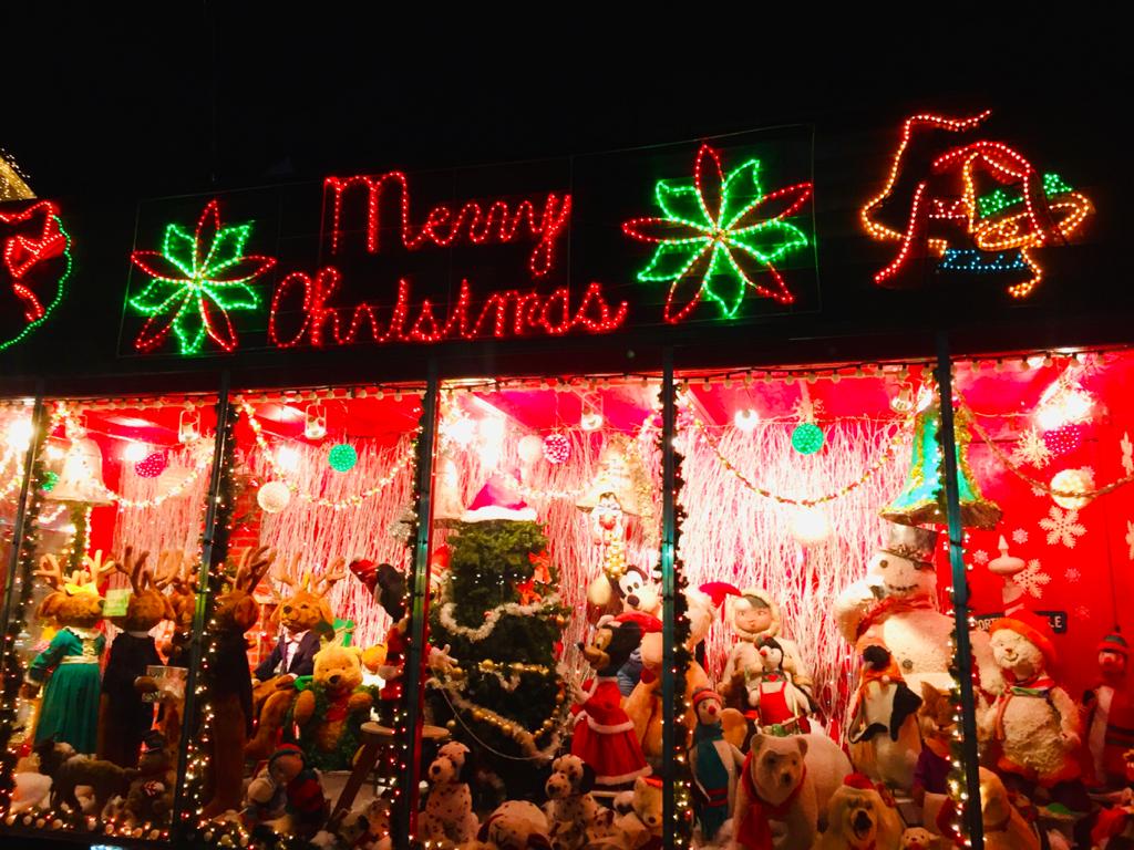 Vers une désacralisation de la fête de Noël en Haïti - A group of people on a stage in front of a store - Christmas lights